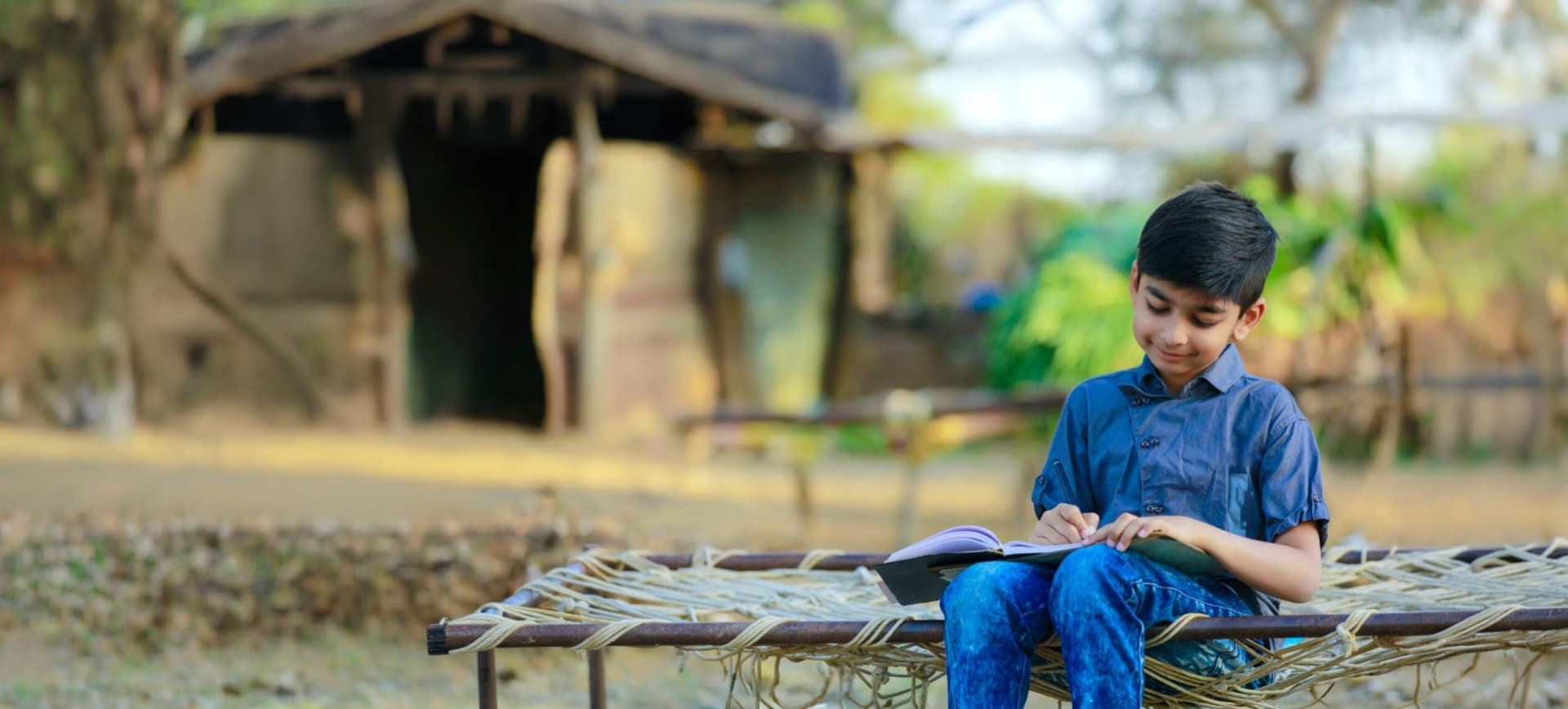 A child reading and writing outdoors